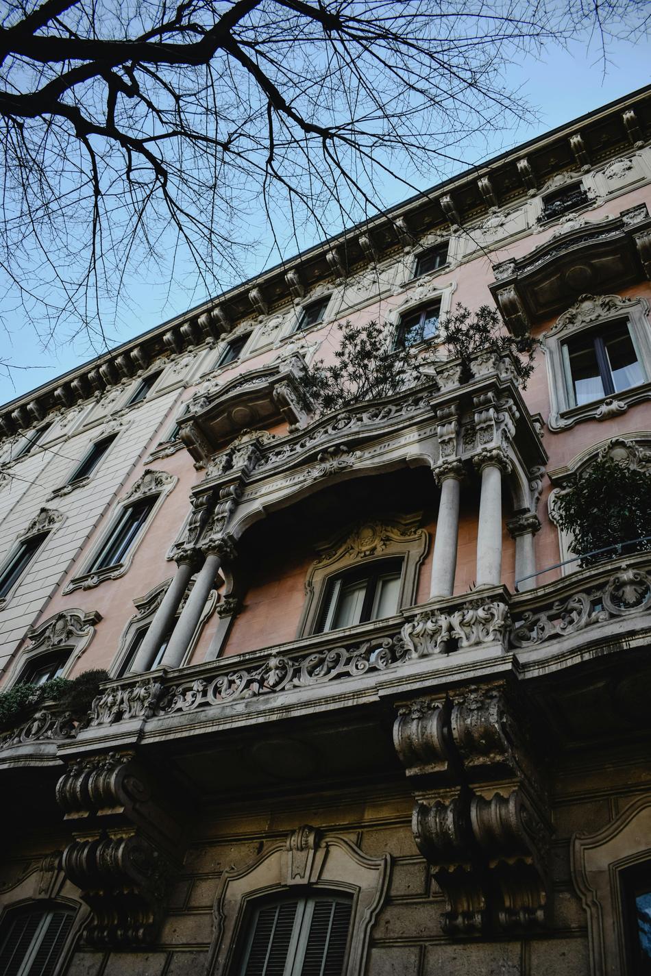 Facciata di un palazzo d'epoca milanese con balconi in pietra